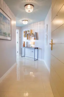 a hallway with white walls and a table in a room at Coconut Grove 10th Fl Studio Parking Included in Miami