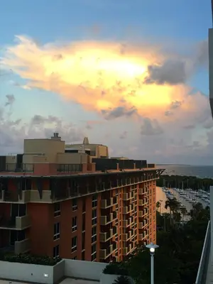 a view of a building and the ocean at sunset at Coconut Grove 10th Fl Studio Parking Included in Miami