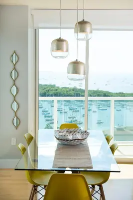 a dining room with a glass table and yellow chairs at Gorgeous Coconut Grove 3 bedroom Condo with amazing views Parking Included in Miami