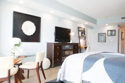 a bedroom with a bed and a table and a tv at Gorgeous Coconut Grove 3 bedroom Condo with amazing views Parking Included in Miami