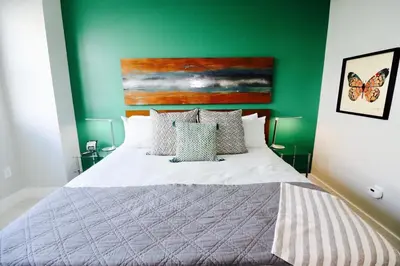 a bedroom with a bed with a green wall at Connecting Rooms-Coconut Grove 21st Floor Parking Included in Miami