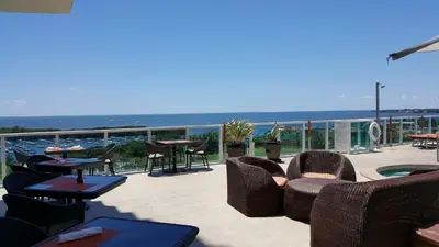 a patio with chairs and tables and a view of the ocean at Coconut Grove 21st Floor Private Studio-Parking & WIFI included in Miami
