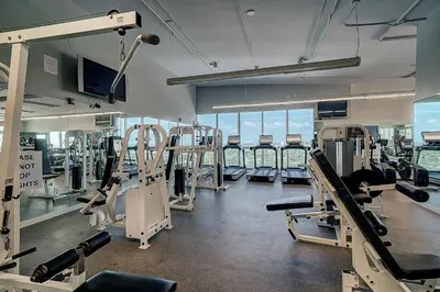 a gym with several treadmills and machines in it at Renovated 21st Floor Private Unit located in Coconut Grove Hotel in Miami