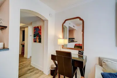 a living room with a desk and a mirror at Cute 1 bedroom unit located in Condo Hotel in the heart of Coconut Grove Free Parking in Miami