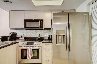 a kitchen with a stainless steel refrigerator and cabinets at Cute 1 bedroom unit located in Condo Hotel in the heart of Coconut Grove Free Parking in Miami