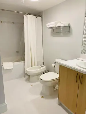 a white bathroom with a toilet and a sink at Cozy 1 bedroom unit located in a Condo Hotel in the heart of Coconut Grove Free Parking in Miami