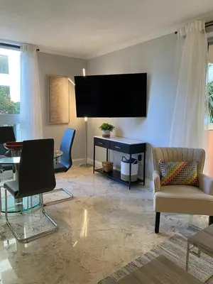 a living room with a flat screen tv on the wall at Cozy 1 bedroom unit located in a Condo Hotel in the heart of Coconut Grove Free Parking in Miami