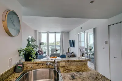 a kitchen with a sink and a large clock on the wall at Coconut Grove 1 bedroom condo parking included in Miami