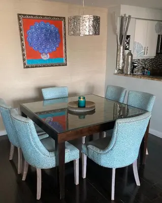 a dining room table with blue chairs and a painting at Luxury Penthouse with Private Rooftop Terrace in Coconut Grove Hotel in Miami