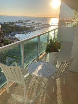 a table and chairs on a balcony with a view of the ocean at Luxury Penthouse with Private Rooftop Terrace in Coconut Grove Hotel in Miami