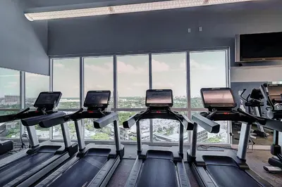 a gym with several treadmills in front of a large window at Luxury 2-story Penthouse located in Coconut Grove Hotel-includes Parking in Miami
