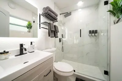 a white bathroom with a toilet and a shower at Modern Apt Near Las Olas Beach in Fort Lauderdale