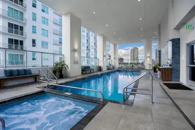 a large swimming pool in a building with a building at Modern Studio Downtown with Pool and Gym in Miami