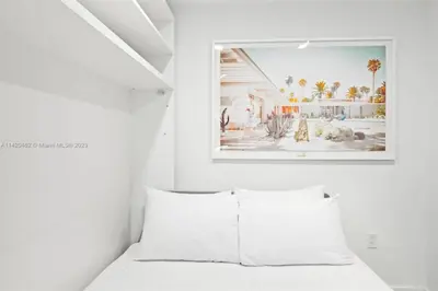a bedroom with a white bed with a picture on the wall at Ocean View Cozy Studio Pool and Gym in Miami