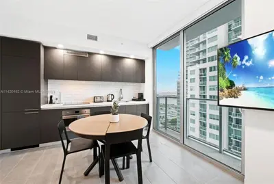 a kitchen and dining room with a table and a tv at Ocean View Cozy Studio Pool and Gym in Miami