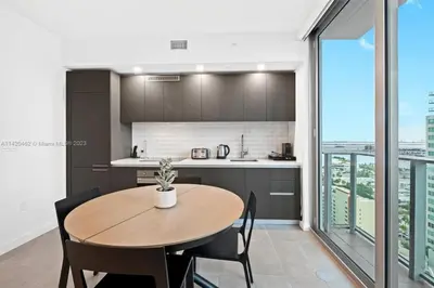 a kitchen and dining room with a table and chairs at Ocean View Cozy Studio Pool and Gym in Miami