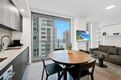 a kitchen and living room with a table and chairs at Ocean View Cozy Studio Pool and Gym in Miami