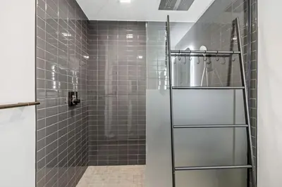 a shower with gray tiles and a glass door at Downtown Luxury Studio Pool and Gym in Miami