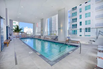 a large swimming pool in a building with windows at Downtown Luxury Studio Pool and Gym in Miami