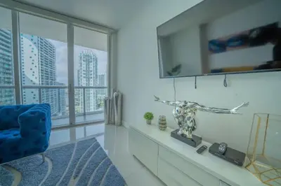 a living room with a blue chair and a window at Deluxe Suite King 1 Bedroom Icon in Miami