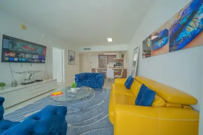 a living room with a yellow couch and blue chairs at Deluxe Suite King 1 Bedroom Icon in Miami