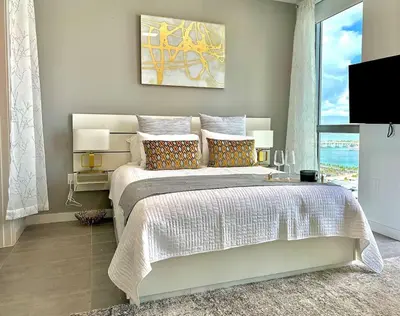 a bedroom with a large bed and a tv at Ocean view Studio Pool and gym in Miami