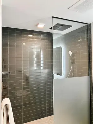 a bathroom with a shower with green tiled walls at Upscale Ocean View Studio Pool and Gym in Miami