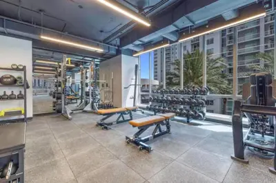 a gym with benches and dumbbells in a building at Upscale Ocean View Studio Pool and Gym in Miami