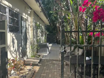 a walkway leading to a house with pink flowers at Tropical Classic Retro Florida, Private 2 bedroom Suite with Best Location in Fort Lauderdale