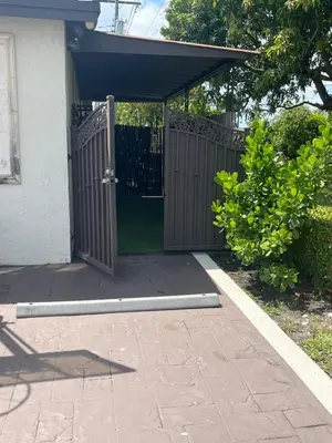 an entrance to a house with a wooden gate at cozy studio apartment with private entrance and patio in Miami