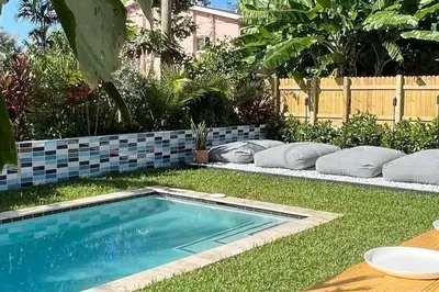 a swimming pool in the middle of a yard at Super stylish 4 BR Home Steps from the Fun in Fort Lauderdale