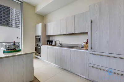 a kitchen with gray cabinets and a large window at Spectacular ocean and beach view in Hollywood