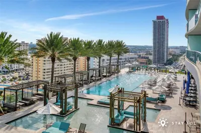 a pool with chairs and palm trees on a building at Spectacular ocean and beach view in Hollywood