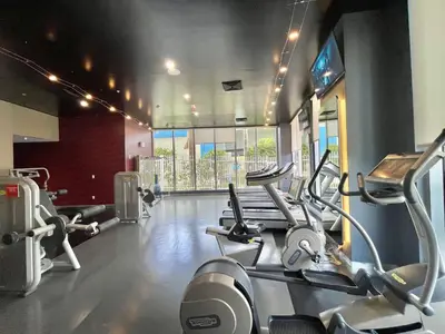 a gym with several cardio machines in a room at Beachwalk Studio (Beach, Pool and Gym) in Hallandale Beach
