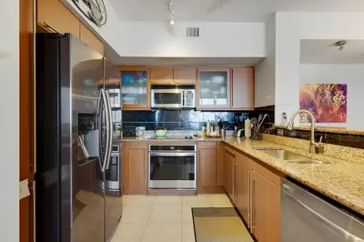 a kitchen with wooden cabinets and stainless steel appliances at 2 BR Monthly beach condo Miami in Hallandale Beach