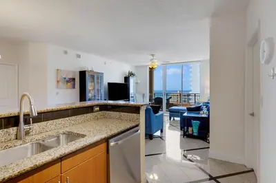a kitchen with a sink and a living room at 2 BR Monthly beach condo Miami in Hallandale Beach