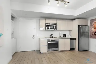 a white kitchen with a sink and a refrigerator at Beachwalk Resort: Amaizing View Balcony Gym Pool in Hallandale Beach