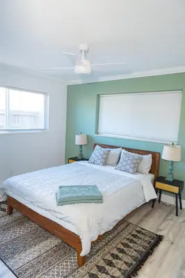a bedroom with a large bed and two windows at Private Villa with Pool and Sauna in Dania Beach