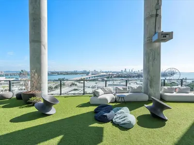 a living room with a couch and chairs on the grass at Downtown by Miami Vacation Rentals in Miami