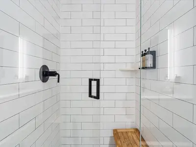 a white tiled shower with a glass door at Downtown by Miami Vacation Rentals in Miami