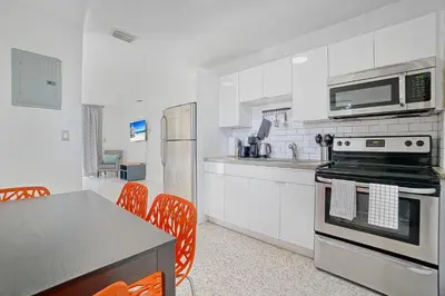 a kitchen with white cabinets and a stove top oven at Elegant Wynwood Flats in Miami
