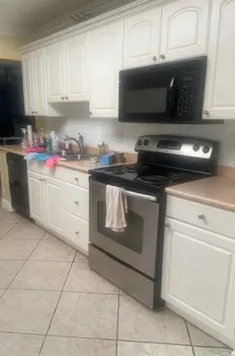 a kitchen with a stove and a microwave at Fort Lauderdale Party house! in Fort Lauderdale