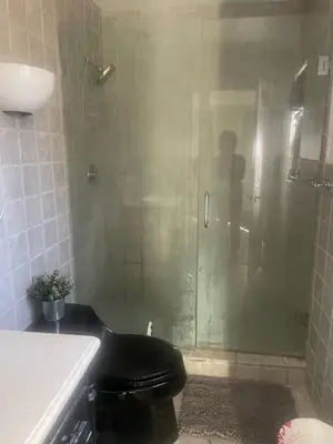 a shower with a black toilet in a bathroom at Fort Lauderdale Party house! in Fort Lauderdale