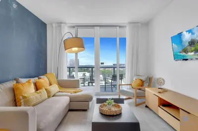 a living room with a couch and a table at Prime Location Amazing Pool Balcony Bay View in Hallandale Beach