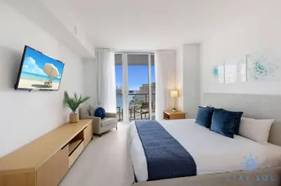 a bedroom with a large bed and a view of the ocean at Spectacular Infinite View Balcony Pool Gym in Hallandale Beach