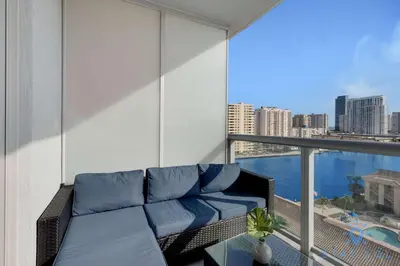 a balcony with a couch and a view of the city at South Beach Retreat Balcony Resort Amenities in Hallandale Beach