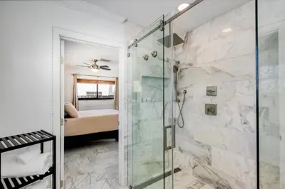 a bathroom with a shower with a glass door at Marble House in Lauderdale Harbours in Fort Lauderdale
