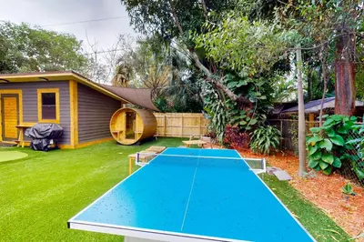 a ping pong table in a backyard with a house at Walking On Sunshine - Studio in Fort Lauderdale