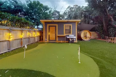 a tiny house with a putting green in a yard at Walking On Sunshine - Studio in Fort Lauderdale