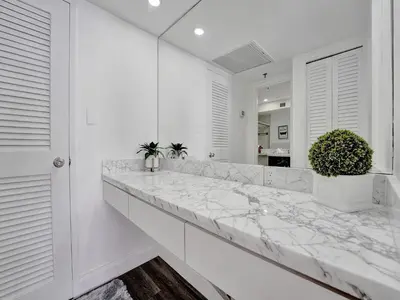 a white kitchen with a marble counter top at Awesome Beach Condo with Resort Amenities 1016 in Miami Beach